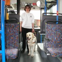 Photo: Josiane Rommes et chien guide Urak entrent dans un bus