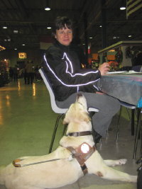 Photo: Le chien guide Urak observe Josiane qui mange une spcialit de la Turquie.