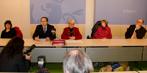 Photo: Les participants de la confrence de presse  une table.